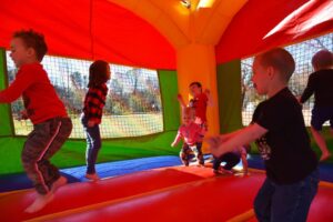 Kids enjoying a safe, clean bounce house provided by Toads Jump party rentals.