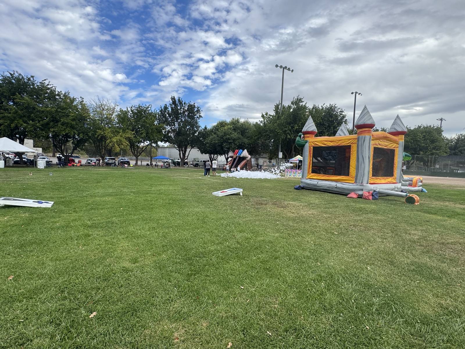 A gray and orange castle bounce house with a foam party and a slide behind it in Ukiah